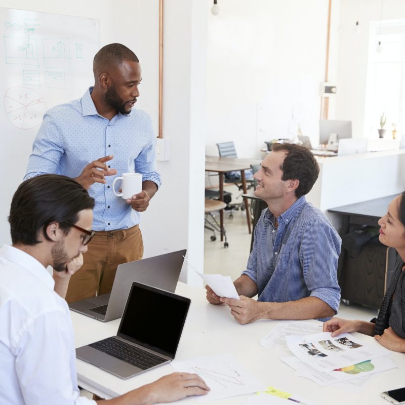 Young black man presenting an office meeting at a whiteboard